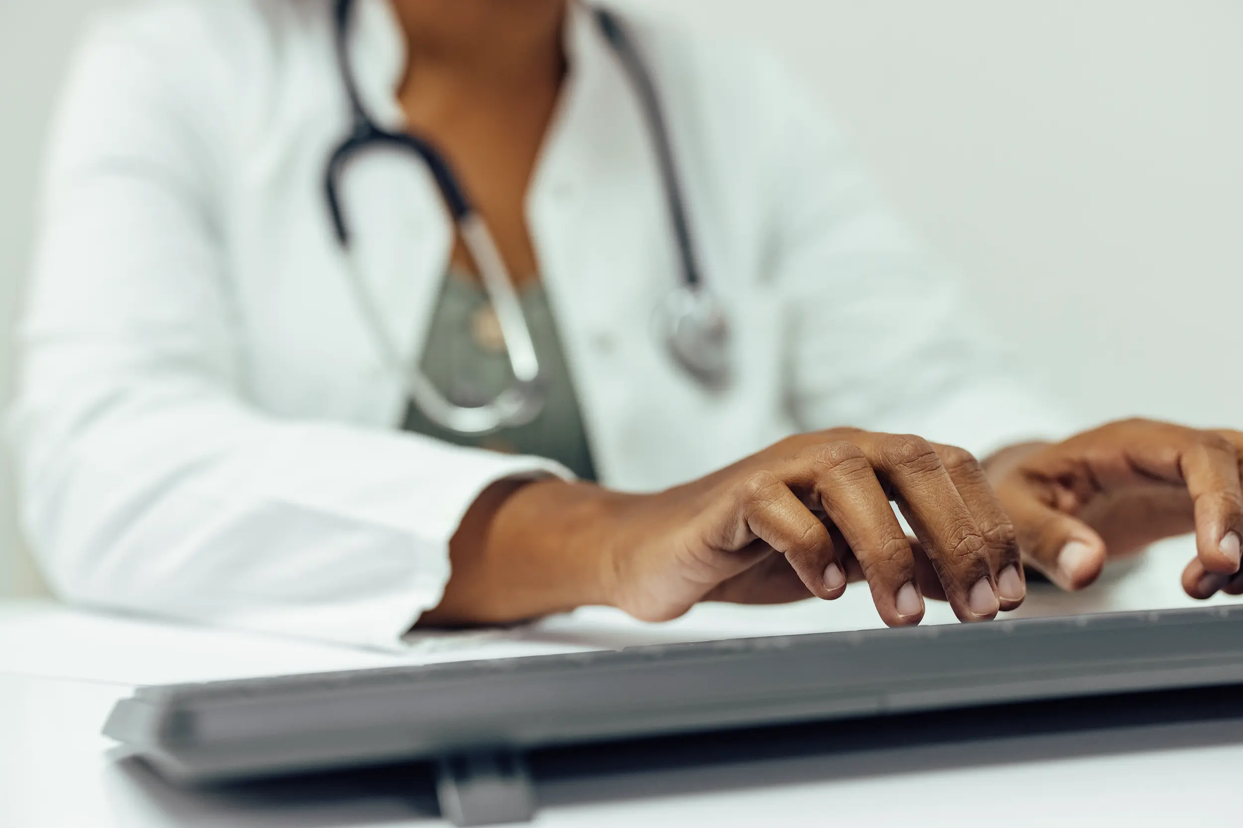 close up of doctor working on computer typing on 2026