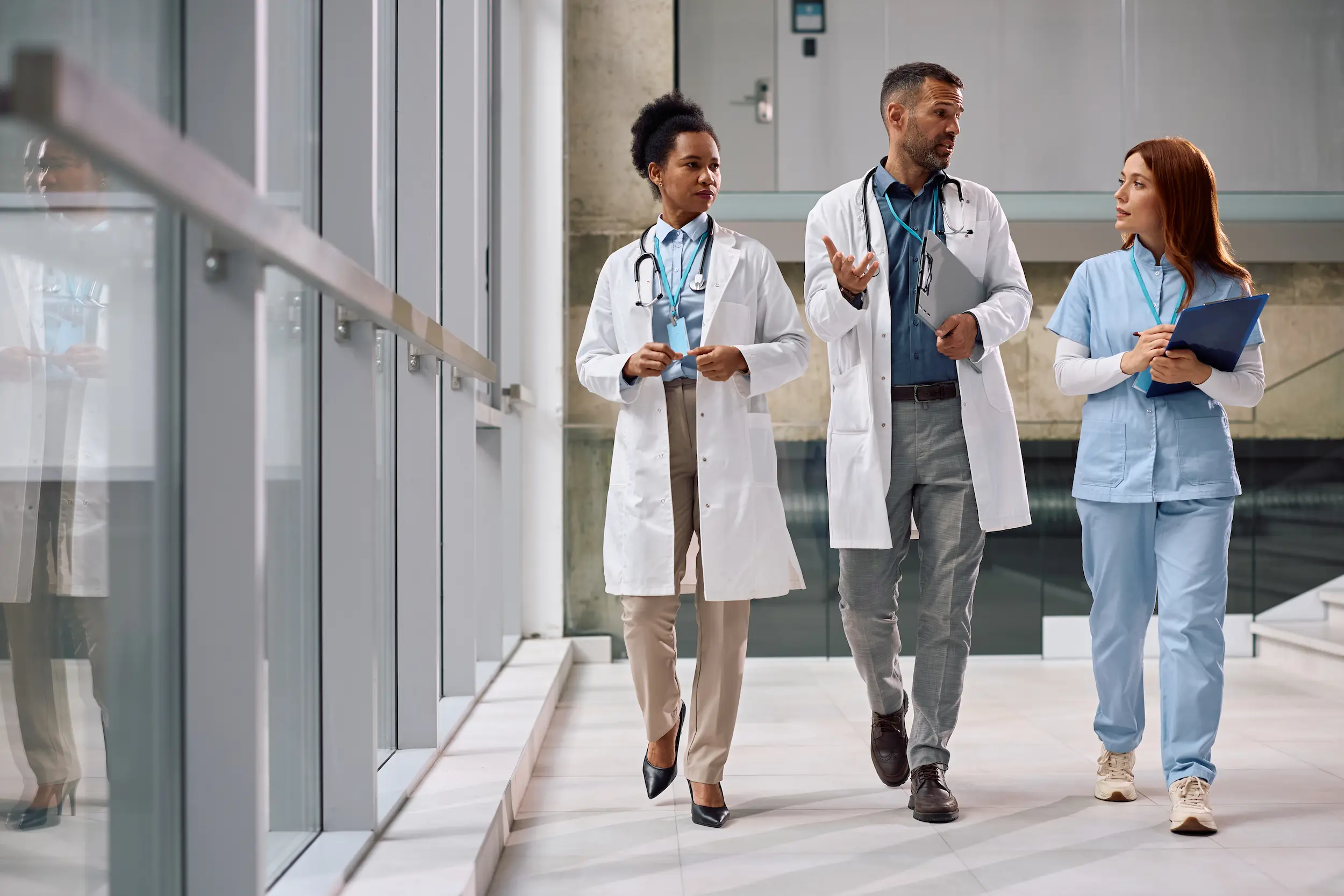 team of healthcare experts talking while walking t 2026